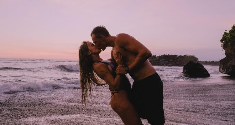 A man kissing woman on the beach