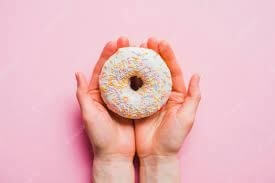 Image of a donut being hold in the hands metaphorically representing the anus of a person to explain what is rimming