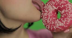 Picture of a girl licking a donut metaphorically representing the practice of rimming